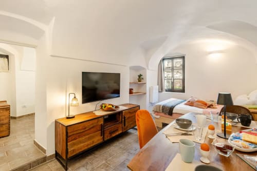 Appartement moderne à Talking Stones à Dolceacqua avec séjour, TV, table à manger et chambre avec vue sur la ville