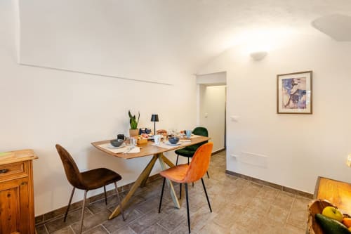 Salle à manger moderne de l'appartement The Residence au Talking Stones B&B à Dolceacqua avec table en bois et chaises colorées