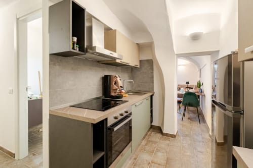 Cuisine moderne à L'Appartement The Residence de Talking Stones à Dolceacqua, avec appareils en acier inoxydable et vue sur la ville