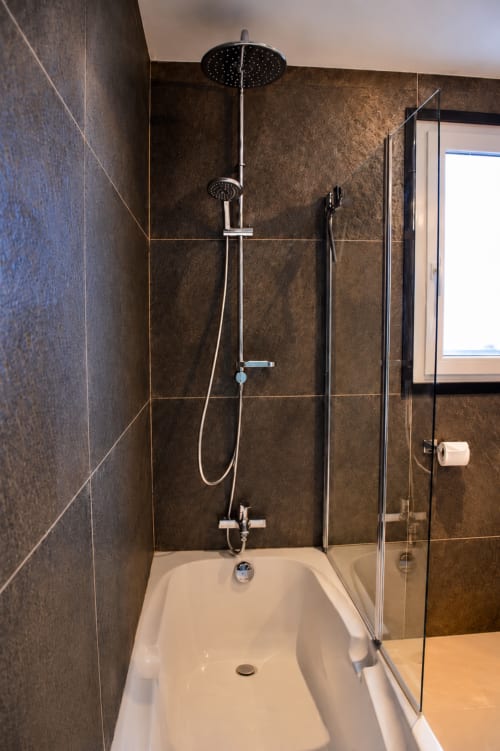 Douche moderne dans la Chambre Cédrat de l'hôtel Au Pied Des Oliviers à Calenzana avec carrelage noir et effet pluie