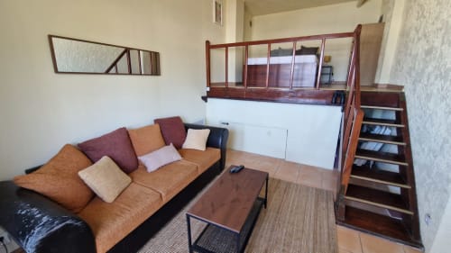 Studio lumineux aux Terrasses des Lecques avec canapé beige, lit mezzanine en bois et vue mer depuis le balcon