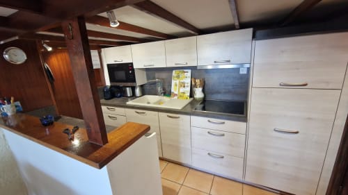 Cuisine moderne avec armoires crème, plan de travail foncé et îlot petit-déjeuner aux Terrasses des Lecques, Saint-Cyr-sur-Mer