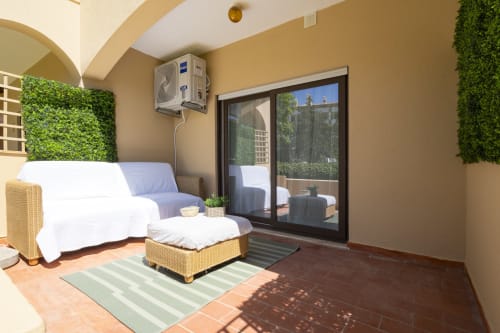 Sala de estar moderna em RB Algarve com assentos confortáveis, ar condicionado e portas de vidro com vista para a piscina