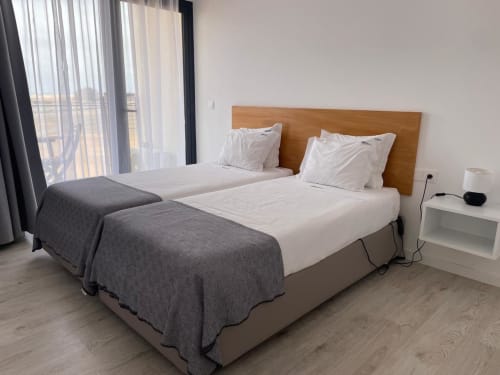 Quarto twin moderno na MedSal Residence em Santa Maria com vista da cidade, cabeceira de madeira e móveis contemporâneos