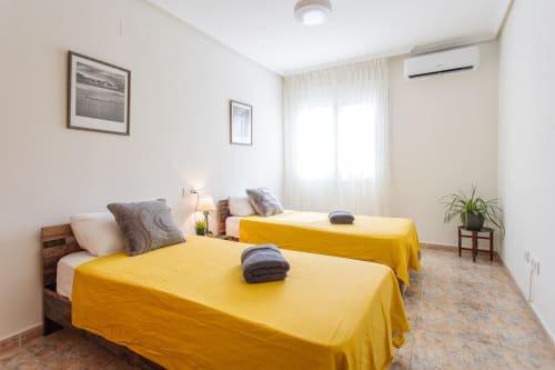 Luminosa habitación doble con colchas amarillas en Haus Holiday Homes, San Pedro del Pinatar, España