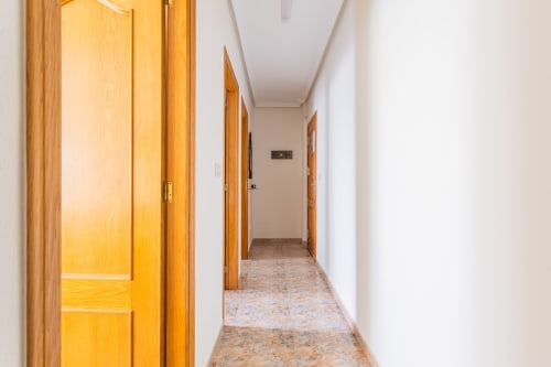 Pasillo luminoso con puertas de madera en el apartamento Haus Holiday Homes, San Pedro del Pinatar, España