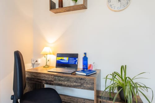 Moderno espacio de trabajo con portátil en el apartamento Haus Holiday Homes de San Pedro del Pinatar, con lámpara, planta y silla