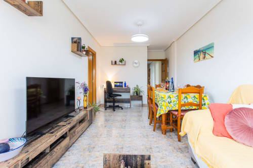 Amplio salón en apartamento de Belchi Beach con TV, comedor, camas y escritorio en San Pedro del Pinatar