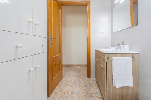 Cuarto de baño moderno en Haus Holiday Homes en San Pedro del Pinatar con mueble de madera, lavabo y espejo
