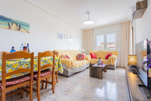 Luminoso salón en apartamento de Belchi Beach, San Pedro del Pinatar con cama litera de madera, sofás amarillos y balcón con vistas al mar