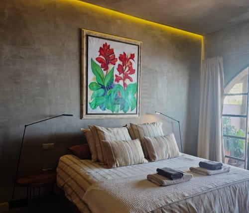 Elegante dormitorio en Les Terrasses Les Suites en Calheta con cuadro de flores rojas, terraza con vista al mar y ropa de cama a rayas.