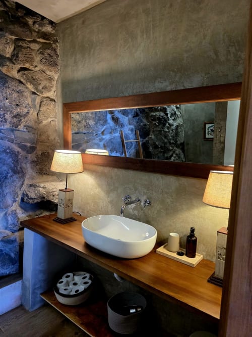 Vanidad de baño moderno con lavabo ovalado blanco, encimera de madera y espejo iluminado en Les Terrasses Les Suites