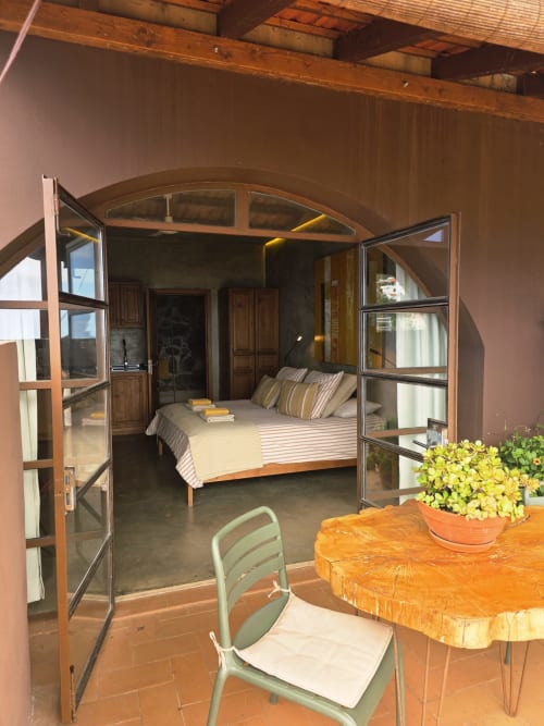 Suite de 3 dormitorios en Les Terrasses Les Suites, Calheta, con terrazas abiertas, ropa de cama a rayas y vistas al jardín