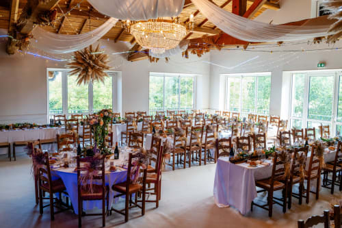 Élégante salle de réception au Hôtel La Métairie à Cordes-sur-ciel avec chaises en bois rustique et plafond drapé