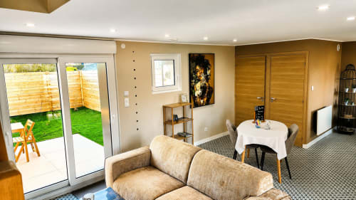 Moderne suite in Ô de Mer in Sangatte met beige bank, eethoek en tuindeuren naar de tuin