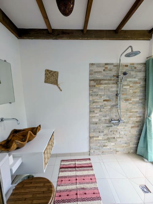 Salle de bain Chambre Faupapa de la pension Fare Tihi Moana à Raiatea : douche en pierre, poutres bois et décor traditionnel