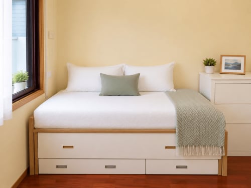 Dormitorio luminoso en el hotel Holibai de Baiona con cama de madera, sábanas blancas y paredes color crema