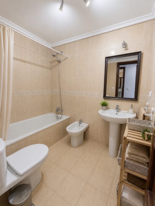 Baño moderno en Holibai Baiona con azulejos beige, lavamanos pedestal, bidé, bañera y ducha