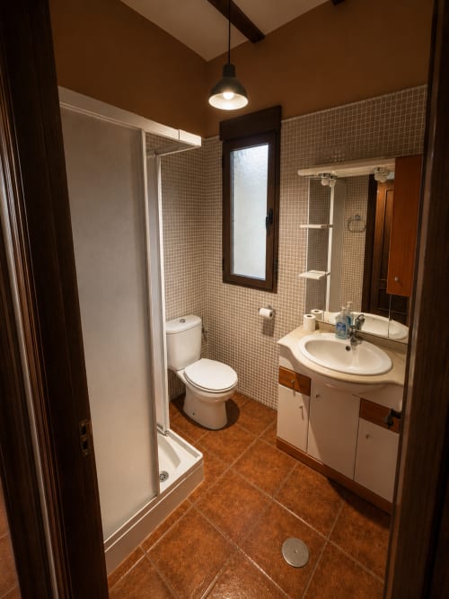 Baño moderno en villa Finca El Arroyo, Alcaraz, con paredes de cerámica, ducha, lavabo, inodoro y toallero calefactable
