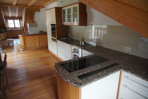 Cucina moderna nell'appartamento The Loft di Rusctlea Apartments a Selva di Valgardena, con top in granito e finiture in legno