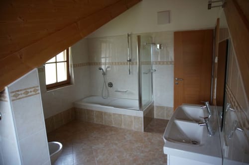 Bagno spazioso negli loft di Rusctlea Apartments con doppi lavandini, doccia walk-in e vista sulle montagne a Selva di Valgardena