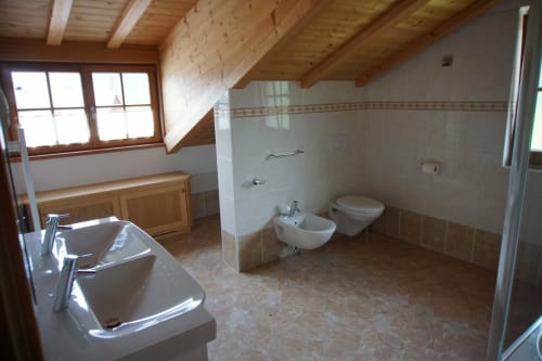 Bagno spazioso nell'appartamento The Loft a Rusctlea, Selva di Valgardena con doppio lavabo, bidet, WC e travi in legno