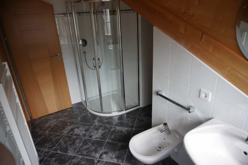 Bagno moderno negli Appartamenti Rusctlea The Loft con cabina doccia, bidet, lavandino e pavimentazione in piastrelle scure a Selva di