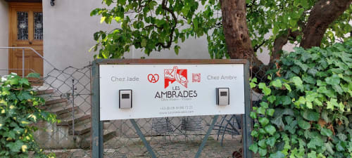 Les Ambrades entrance sign for Chez Jade cottage in Eguisheim, with ivy-covered gate and wooden door