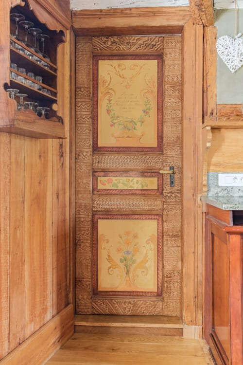 Decorated wooden door with floral panels at Chez Jade cottage in Eguisheim, Les Ambrades