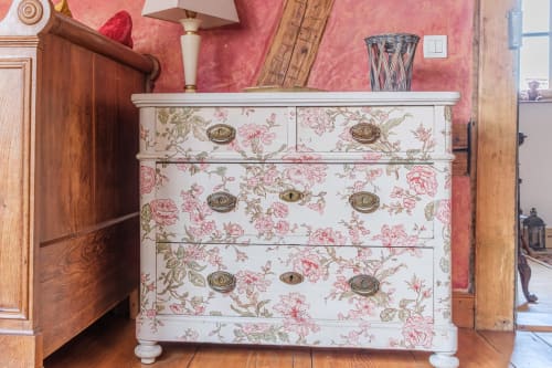 Floral decorated chest of drawers at Les Ambrades cottage in Eguisheim against pink wallpapered wall