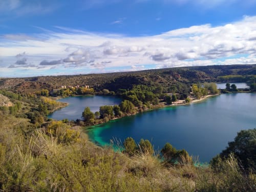 Vista panorámica del lago con colinas verdes y vegetación cerca de Finca El Arroyo, Alcaraz