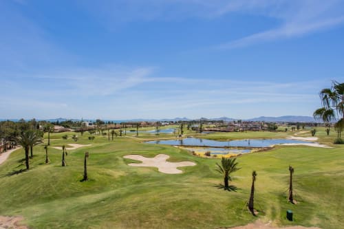 Campo de golf con fairways verdes, búnkeres de arena y obstáculos de agua azul en el resort San Pedro del Pinatar, España