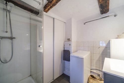 Modern bathroom at Les Ambrades villa in Eguisheim with walk-in shower, toilet, and exposed beams