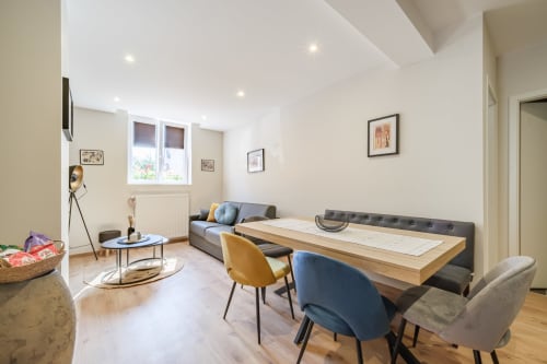 Modern apartment living area at Les Ambrades, Kaysersberg-Vignoble, with dining table, sofa, and contemporary furnishings
