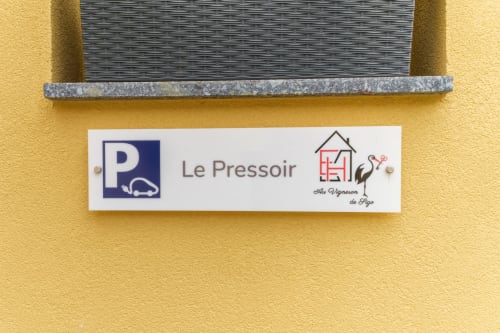 Schild "Le Pressoir" an gelbem Mauern des Landhauses Les Ambrades, Kaysersberg