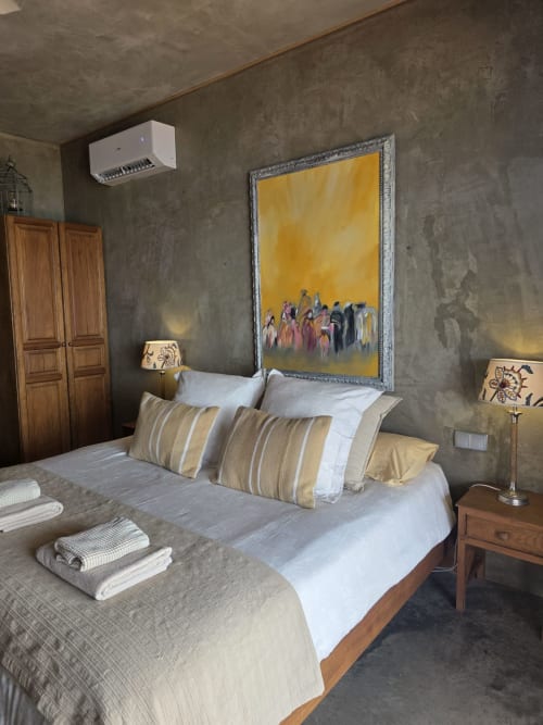 Dormitorio espacioso en Les Terrasses Les Suites de Calheta con cama de madera, almohadas rayadas, cuadros amarillos y diseño moderno