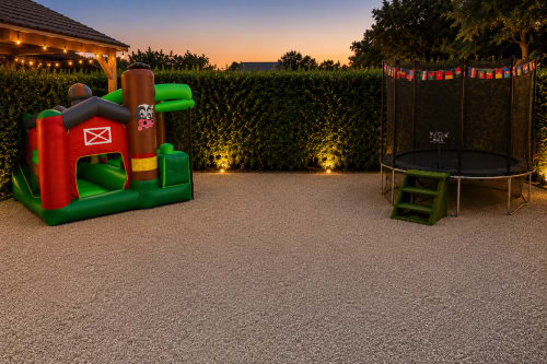 Aire de jeux extérieure de l'Hôtel de Champagne à Saint-Dizier avec château gonflable et trampoline au crépuscule