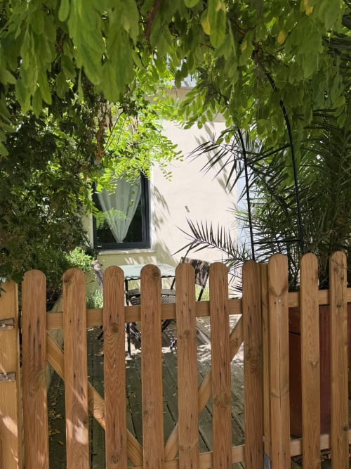 Clôture en bois et plantes verdoyantes encadrant une terrasse à l'appartement Maison Dormoy à Marseille