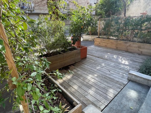 Terrasse indépendante à la Maison Dormoy Marseille avec terrasse en bois, jardinières de plantes vertes et vue sur la ville