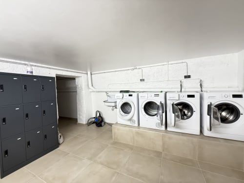 Buanderie moderne à la Villa58 Mattbnb de Metz avec machines à laver blanches et casiers de rangement foncés