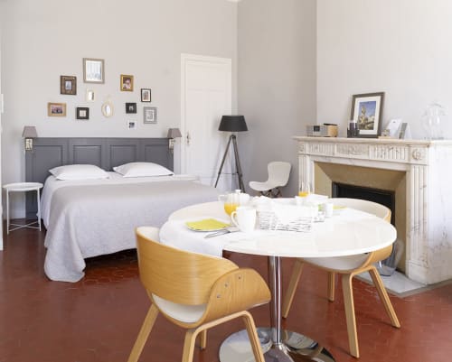 Chambre moderne à l'hôtel Maison Dormoy à Marseille avec lit, table à manger ronde, cheminée et espace bureau