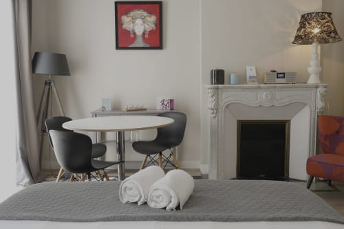 Suite Suzan à la Maison Dormoy à Marseille avec salle à manger, cheminée et serviettes roulées sur le lit