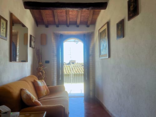 Luminoso corridoio con portale ad arco che si apre sulla terrazza con vista sul castello di torniella