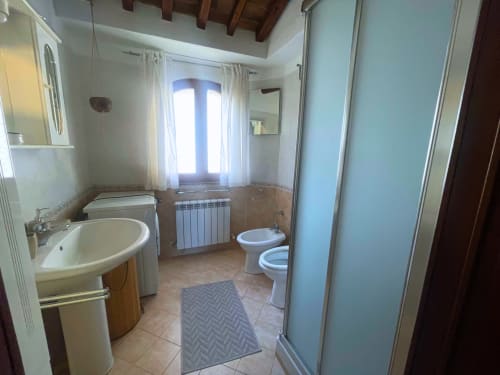 Ampio bagno con lavabo rotondo, wc, bidet e cabina doccia