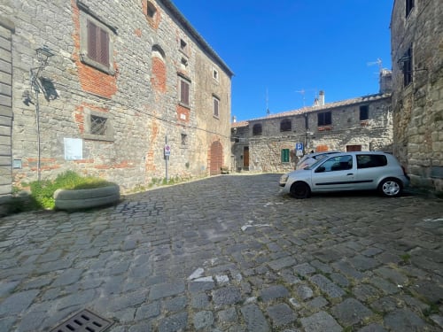 Cortile medievale in pietra nel borgo dove si può parcheggiare.