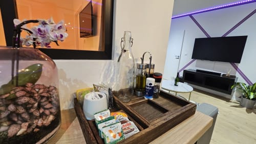 Petite cuisine moderne à la Résidence L'Hermitière avec télévision écran plat, fleurs et décoration en bois