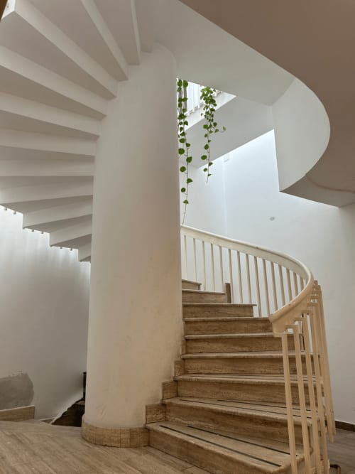 Scala a spirale moderna con gradini in legno e ringhiere bianche nell'appartamento Palazzo di Villa D'Alessandro ad Anacapri