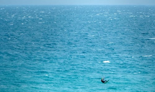 Kitesurfeur sur les eaux turquoise méditerranéennes près de Roquebrune-Cap Martin, vue sur mer de l'appartement Riviera Home
