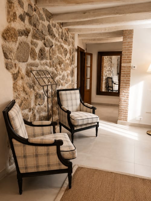 Rustic stone hallway with two upholstered chairs at El Escondite De Pedro Malillo, Candeleda
