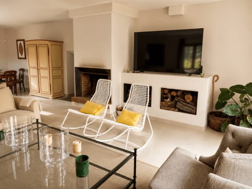 Modern living room at El Escondite De Pedro Malillo in Candeleda with fireplace, TV, and white rocking chairs